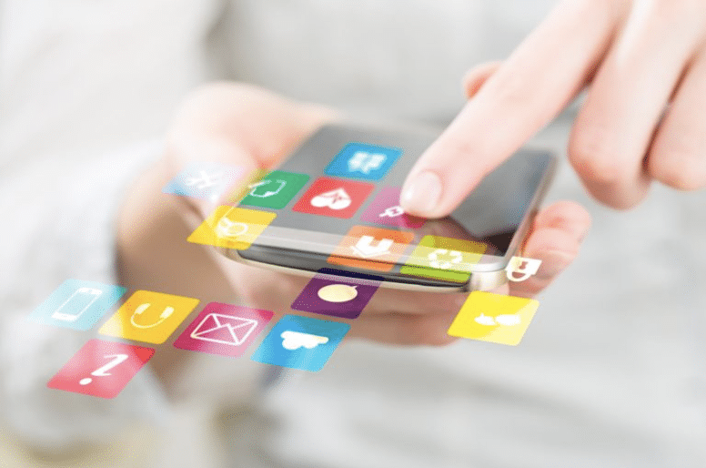 Person using a smartphone with colorful application icons floating from the screen.