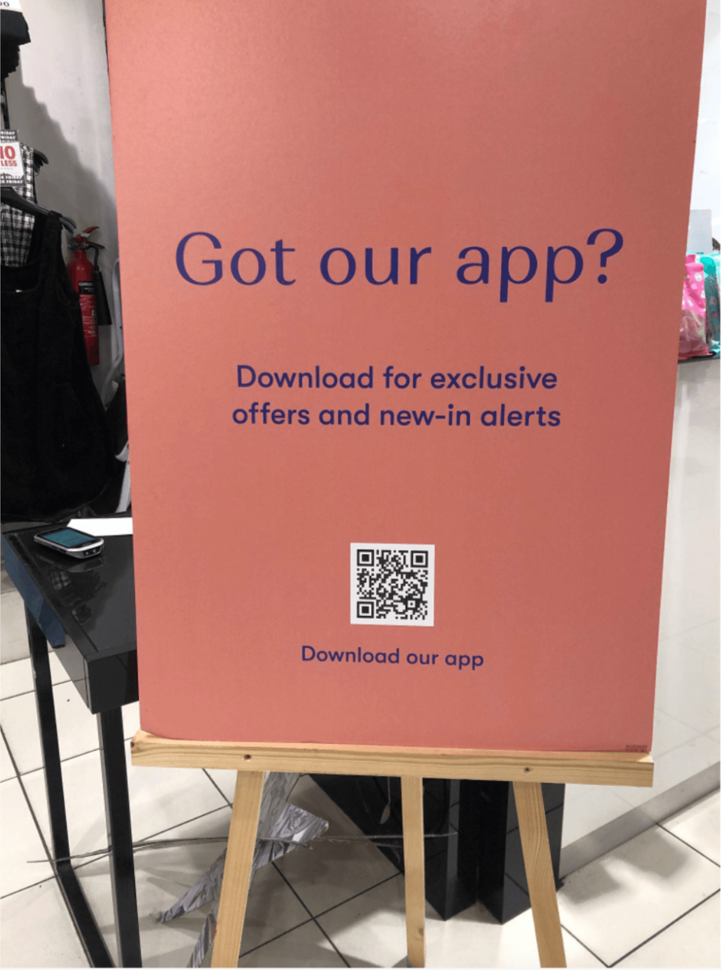 Picture of an in-store sign: "Got our app?" The sign shows a scannable QR code to take shoppers to the app.