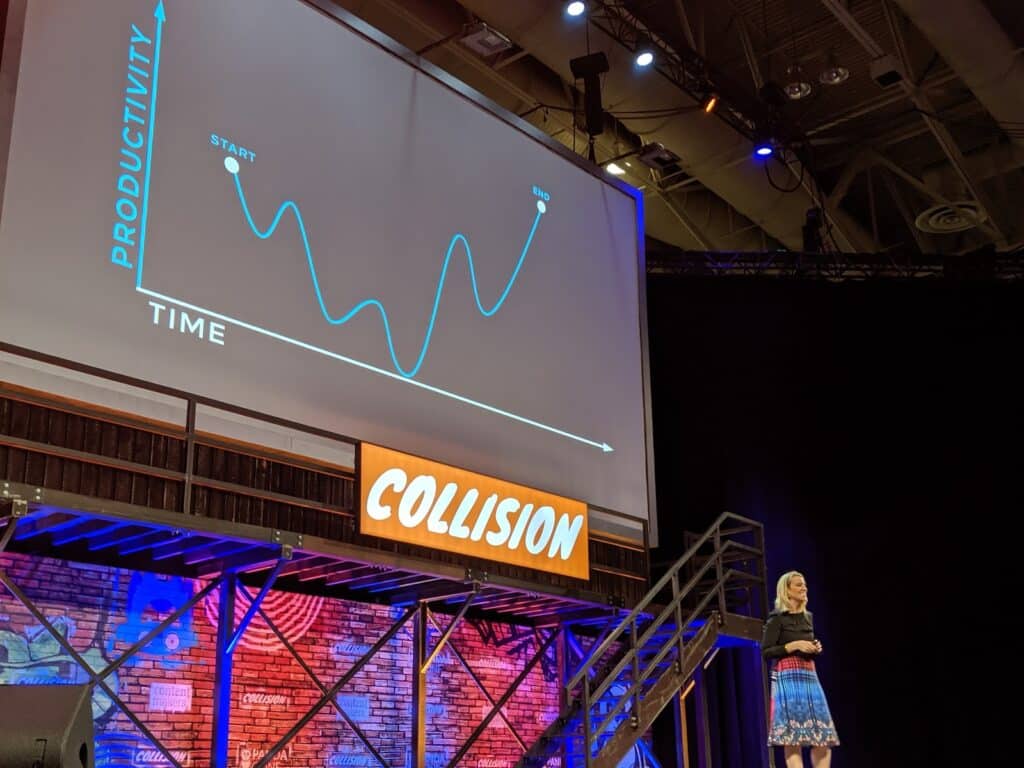 Speaker at Collision conference presenting a slide showing a fluctuating productivity vs. time graph from start to end