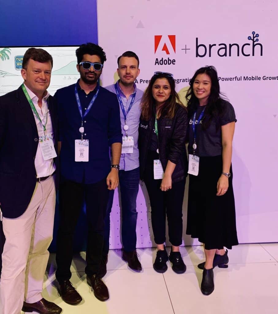 Group of people standing in front of Adobe and Branch conference banner.