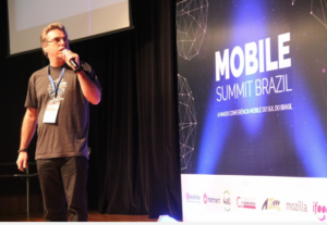 Man speaking on stage at Mobile Summit Brazil conference.