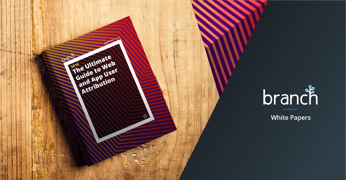 Book titled "The Ultimate Guide to Web and App User Attribution" by Branch, displayed on a wooden surface with vibrant striped cover design.