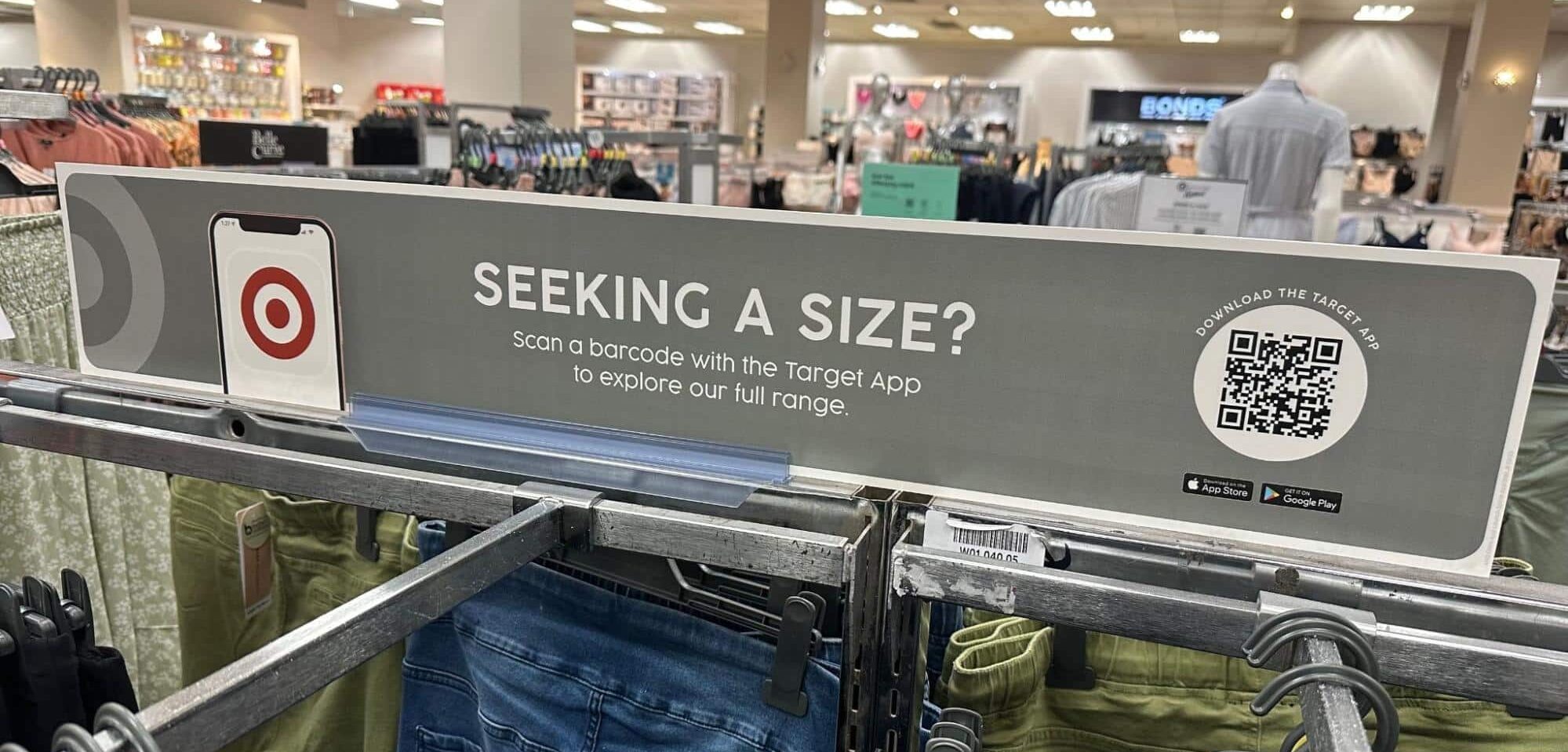 Target in-store QR code displayed on a clothing rack: "Seeking a size?"